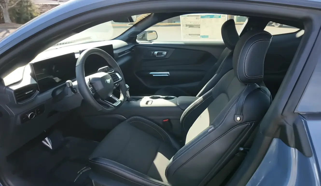 Ford Mustang EcoBoost 2026 interior showing large digital dashboard screens modern tech best cabin materials in group most supportive seats for tall drivers and most comfortable for long-distance driving among affordable coupes under 40000