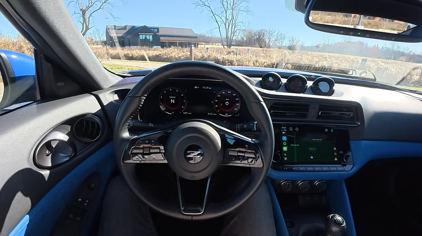 Nissan Z Sport 2026 interior showing modern tech setup with large screens automatic transmission option and aggressive sports coupe character for the 400 hp honorable mention in the best budget sports car comparison 2026