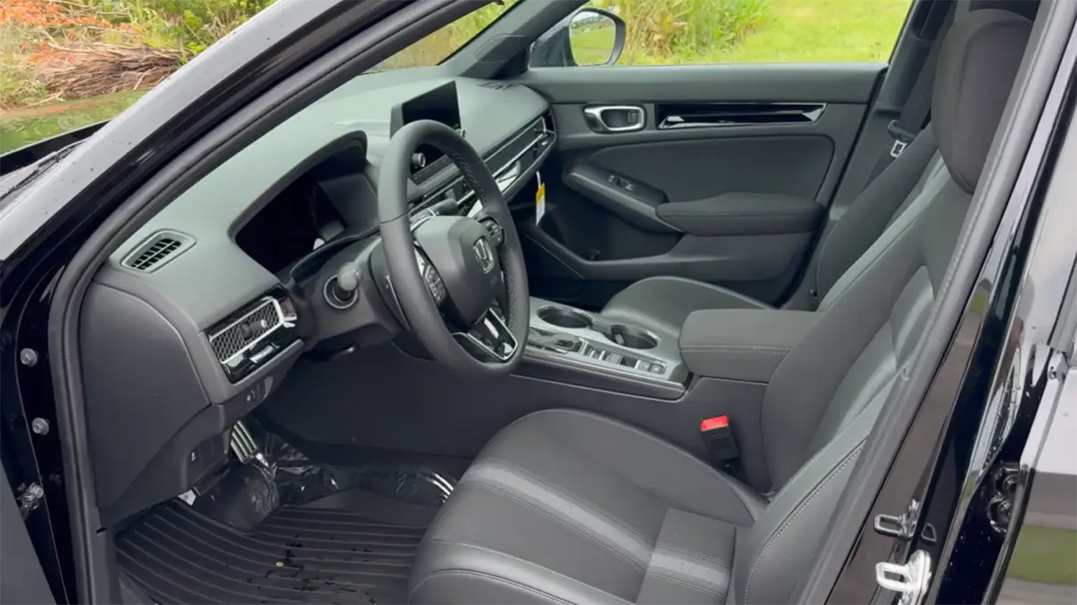2026 Honda Civic interior showing 9-inch crisp touchscreen physical climate control knobs modern cabin design wireless Apple CarPlay and rear legroom advantage over Toyota Corolla Hybrid 8-inch screen