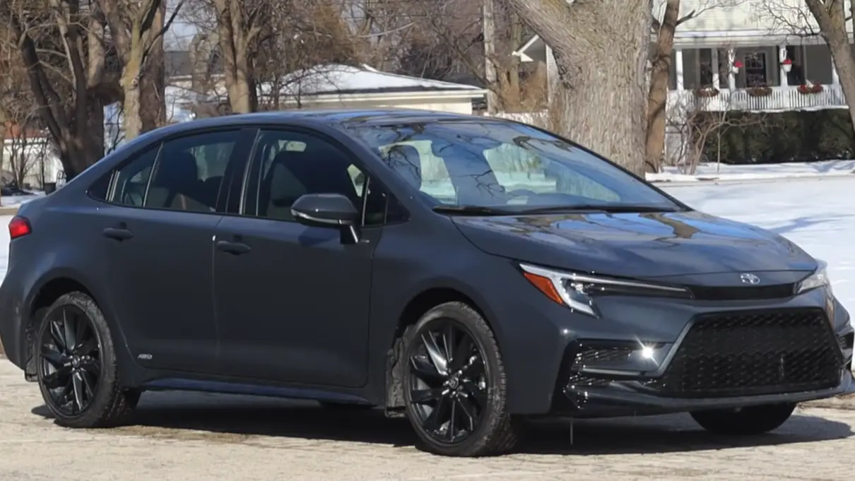 2026 Toyota Corolla Hybrid showing Toyota Safety Sense standard equipment adaptive cruise automatic emergency braking lane keeping assist and 8 inch touchscreen in hybrid compact sedan comparison against Honda Civic