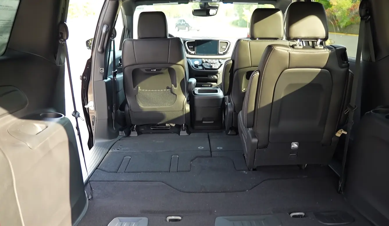 Chrysler Pacifica Hybrid 2026 cargo space showing 32.3 cubic feet with rear seats up Stow and Go flat floor system and massive cargo bay without heavy chair lifting confirming best people carrier MPV 2026 for small families