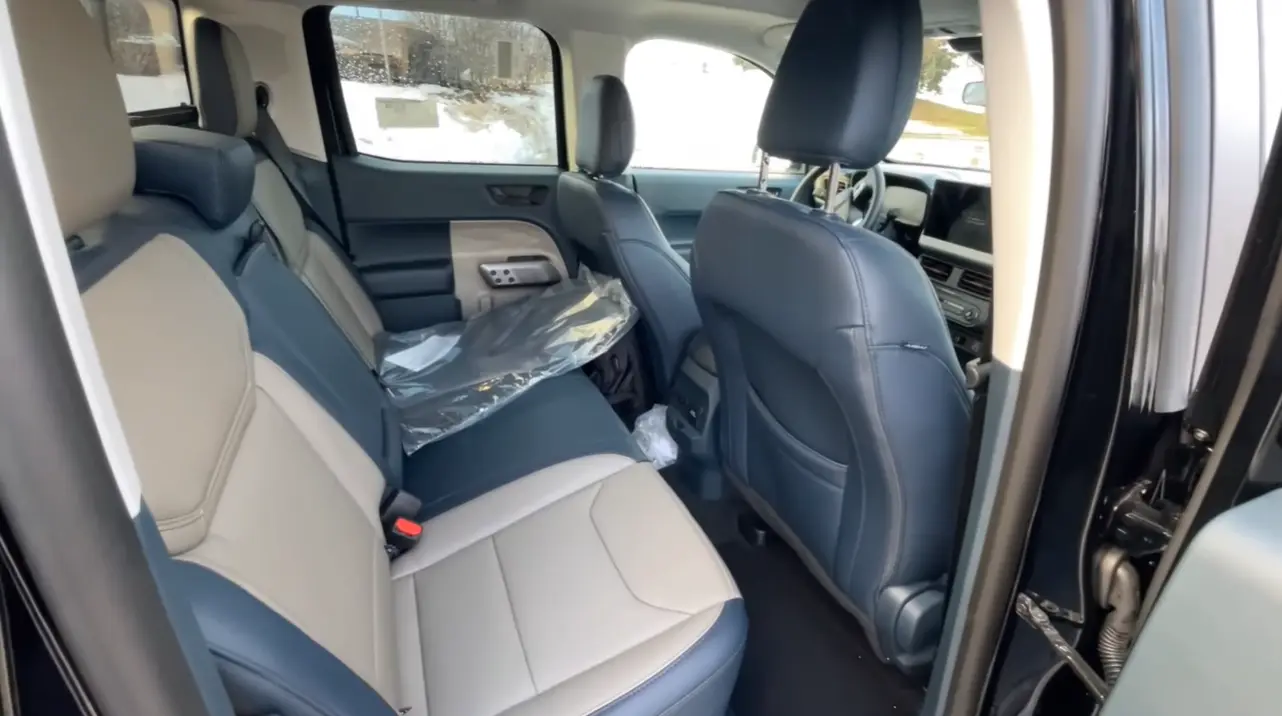 Ford Maverick 2026 hybrid rear seating space showing crew cab five-passenger layout two child seats confirmed fitting side by side tight rear footroom for tall adults and hidden bin under rear seat for tools snacks and sports gear