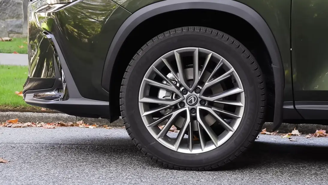 Lexus NX 350h 2026 wheel and SUV stance showing compact luxury SUV proportions AWD availability 22.7 cubic feet cargo space and premium Lexus design that beats BMW X3 and Volvo XC60 on fuel economy at 40 mpg combined