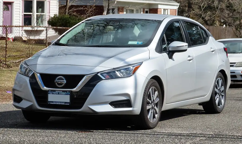 Silver 2020 Nissan Versa SV sedan parked on a residential street, front three-quarter view