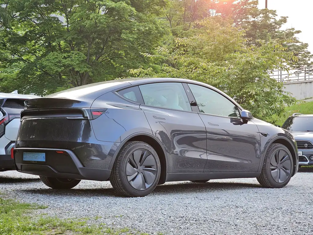 2025 Tesla Model Y (Juniper refresh) - rear 3/4 exterior, Stealth Grey