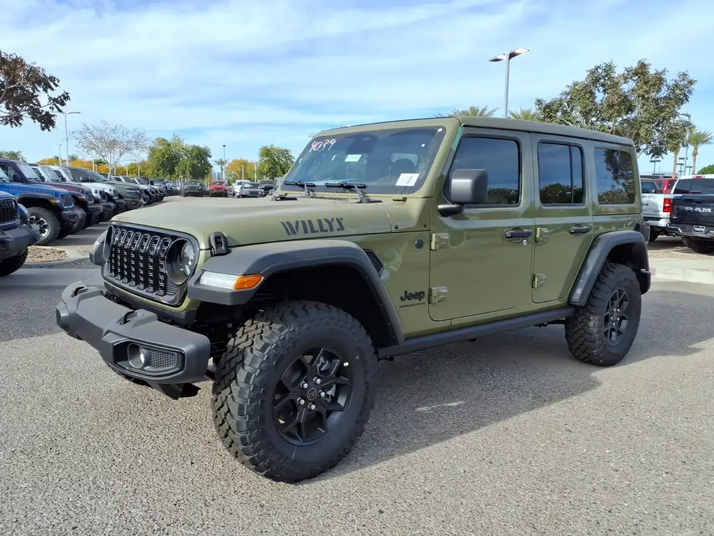 Green 2026 Jeep Wrangler Willys 4-door with a body-color hardtop and Willys hood decal on a dealer lot