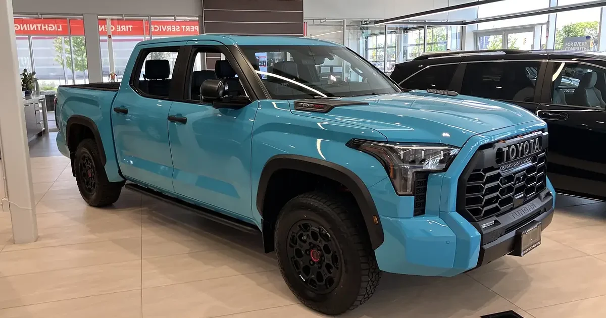 Light blue 2026 Toyota Tundra TRD Pro CrewMax in a dealer showroom, with black TRD Pro wheels and TOYOTA heritage grille