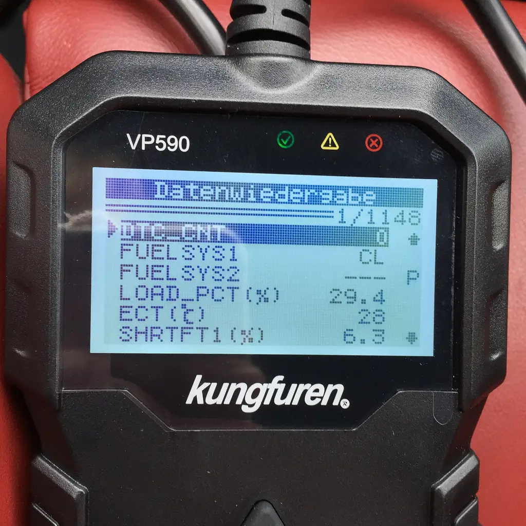 Handheld OBD2 scanner screen showing live data such as fuel system status and engine load