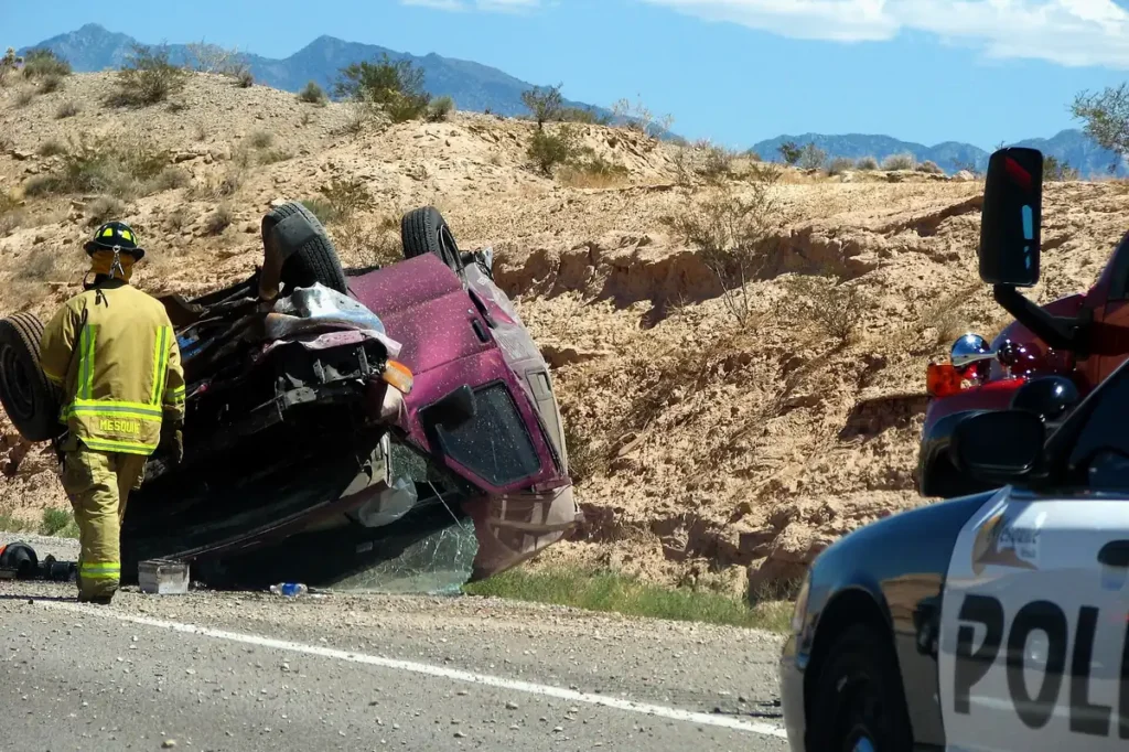 Firefighter and police at a rollover crash scene on a desert highway (Wikimedia Commons, CC BY 2.0)