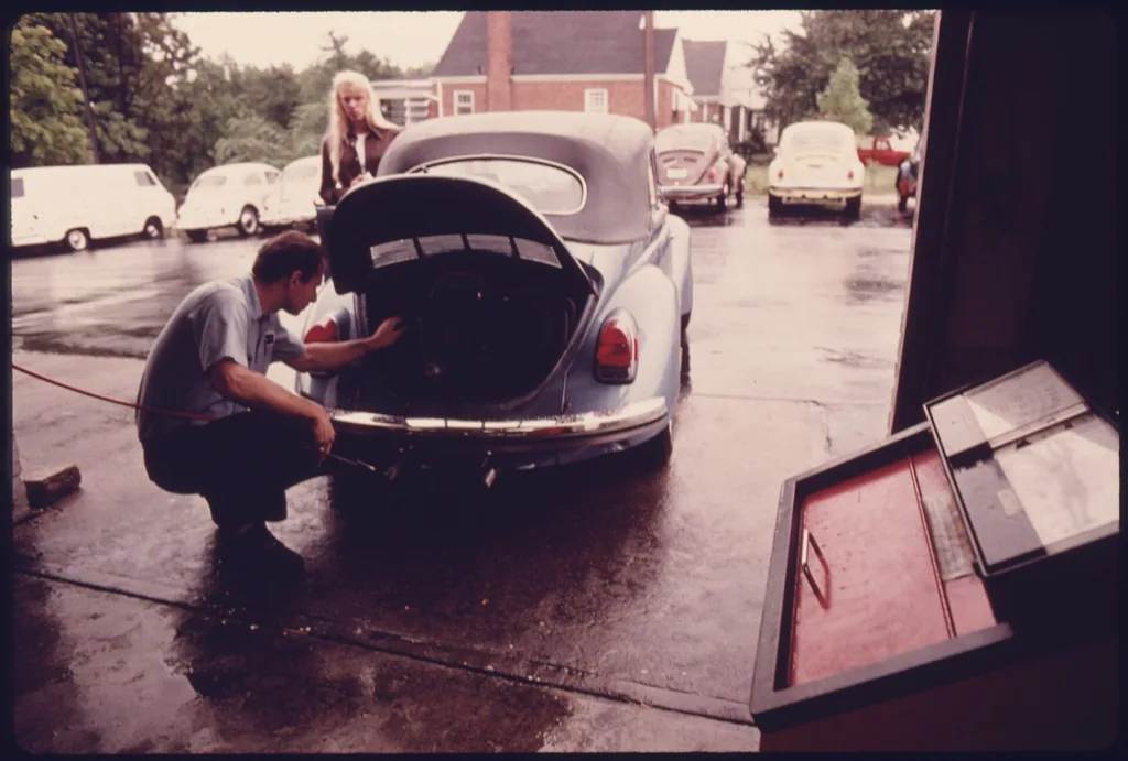 Mechanic adjusting an engine after a failed emissions test, U.S. National Archives photo (public domain)