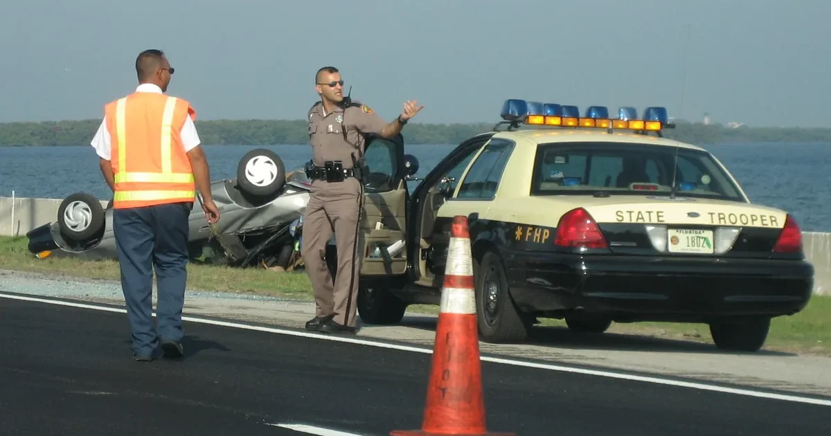 Florida Highway Patrol trooper directing traffic at a crash scene (Wikimedia Commons, public domain)