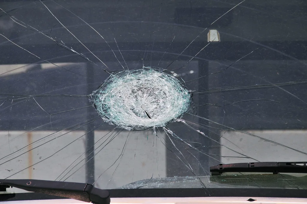 Hail-damaged vehicle windshield in Moore, Oklahoma, 2010; weather losses feed comprehensive premiums (public domain, FEMA via Wikimedia Commons)