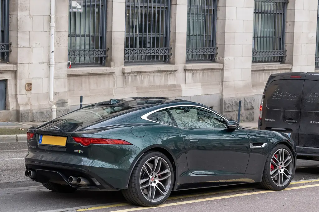 Green Jaguar F-Type R Coupe parked on a street, same model as Deckard Shaw's car in The Fate of the Furious