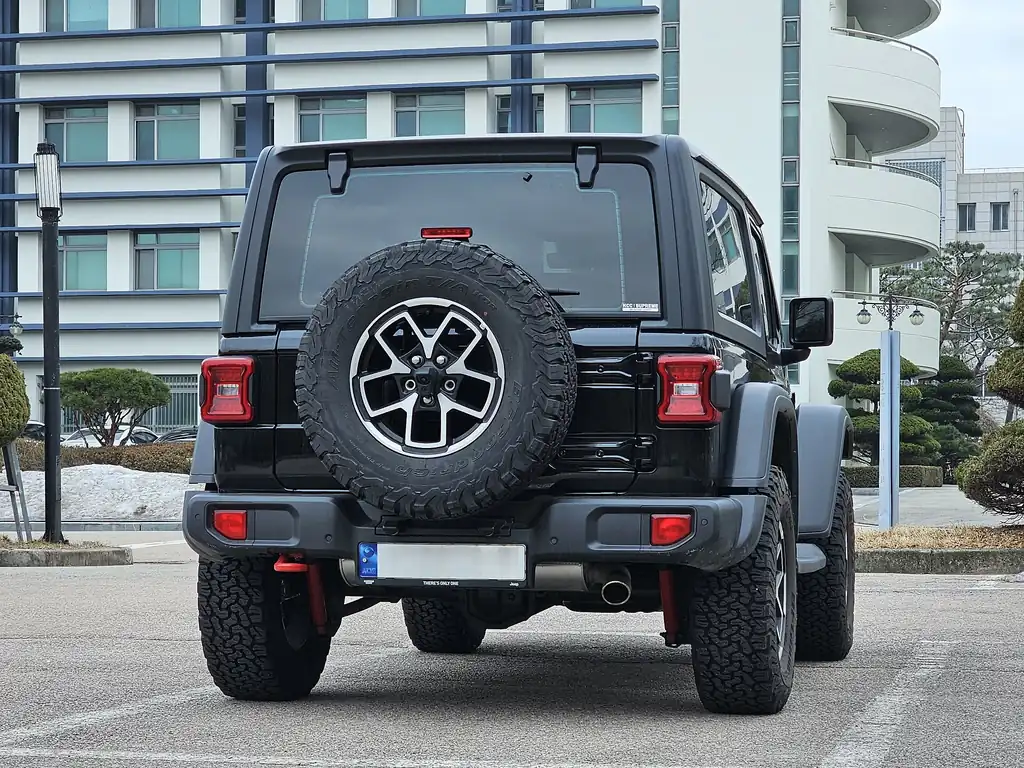 Jeep Wrangler Rubicon 2-door (JL facelift, 2024+ MY) - rear 3/4 exterior, black (plate blurred)