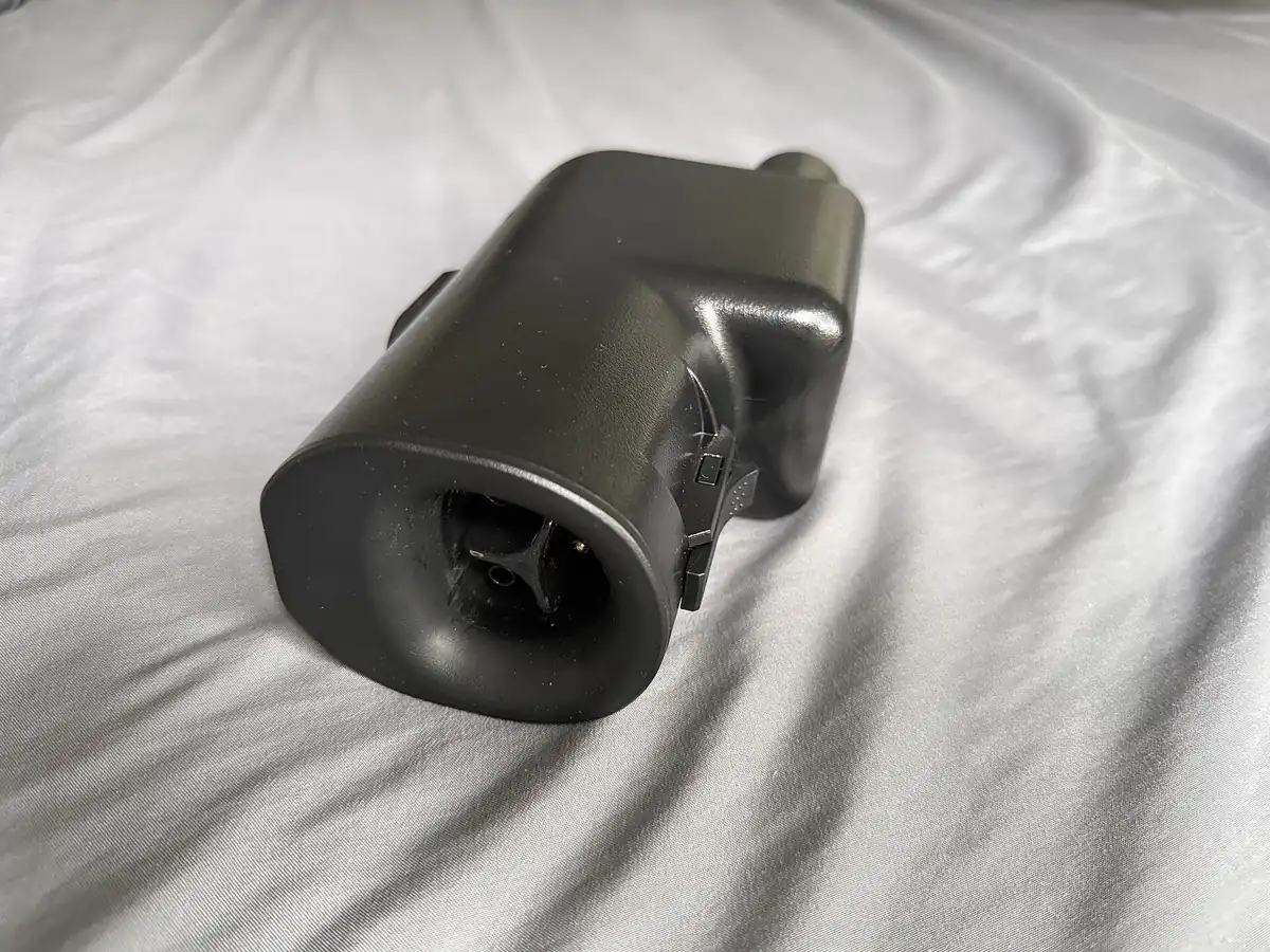 A NACS-to-CCS1 charging adapter resting on a white surface