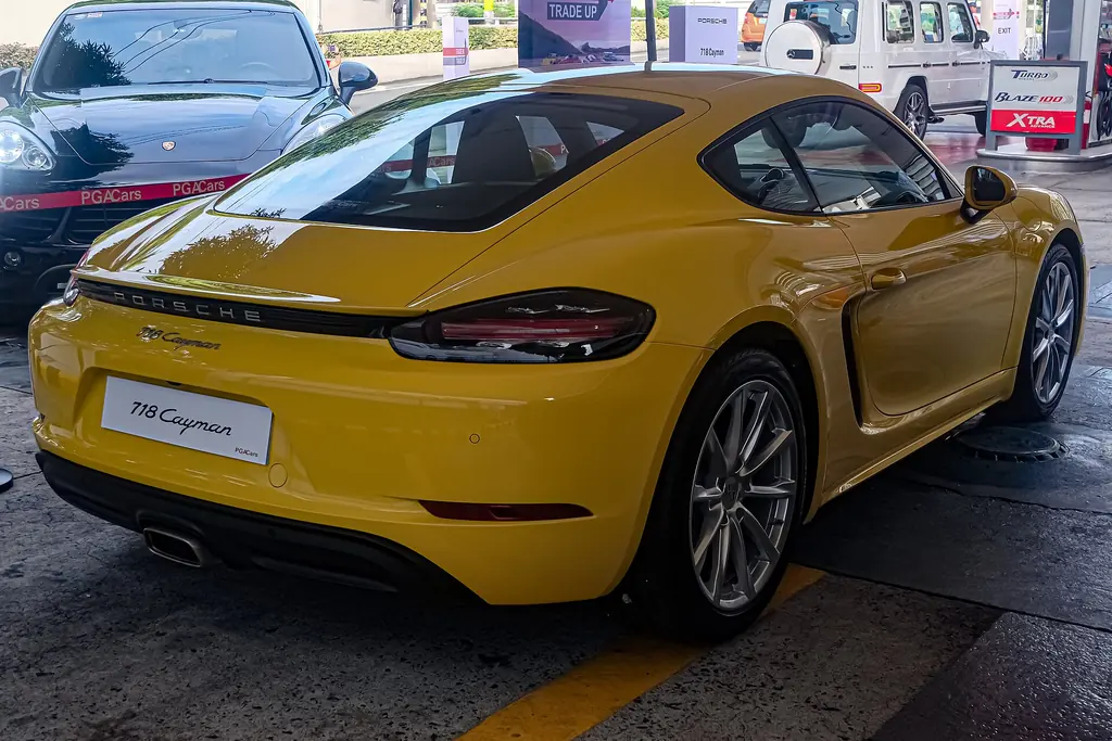 Porsche 718 Cayman (982) - rear 3/4 exterior, Racing Yellow