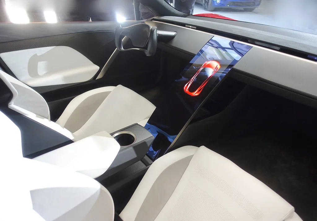 Interior of the 2017 Tesla Roadster prototype showing yoke-style steering wheel, center screen and white seats