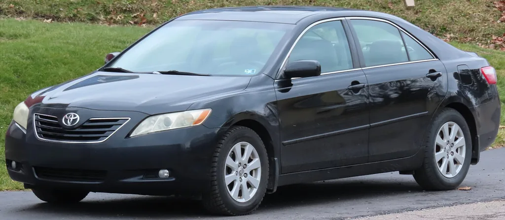 Black 2007-2009 Toyota Camry XLE sedan parked on a street, side-front view