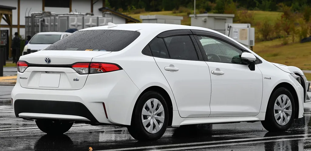 Toyota Corolla Hybrid sedan (12th gen E210) - rear 3/4 exterior, white