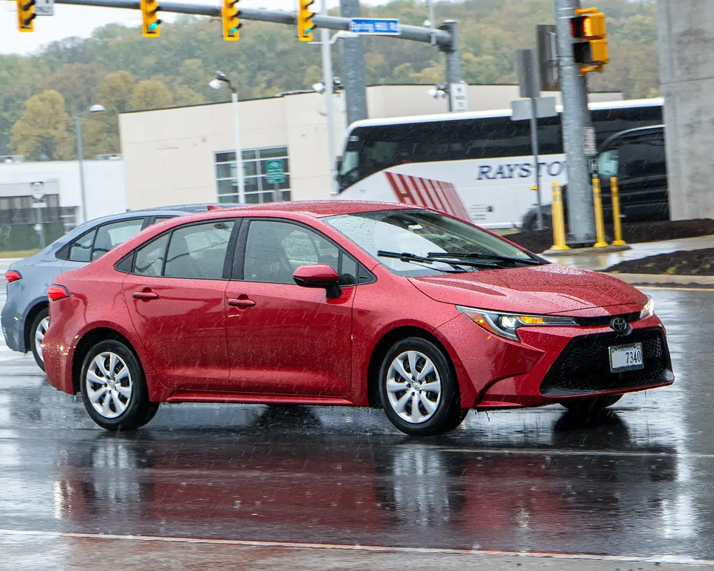 Toyota Corolla LE sedan (E210) - front 3/4 exterior, red