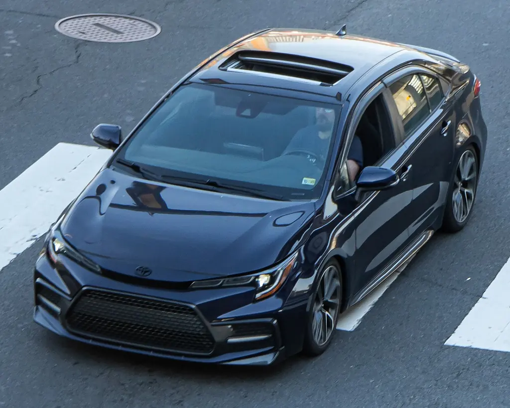 Toyota Corolla SE sedan (E210 facelift) - front 3/4 exterior, dark blue