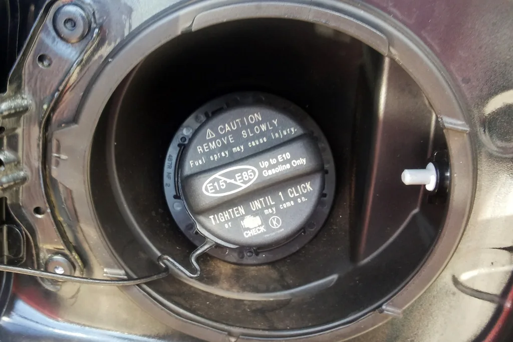 Toyota Camry fuel filler cap marked Tighten Until 1 Click inside the open fuel door