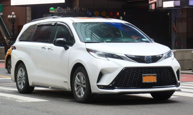 White 2021 Toyota Sienna XSE Hybrid minivan, front three-quarter view, on a city street in Midtown Manhattan